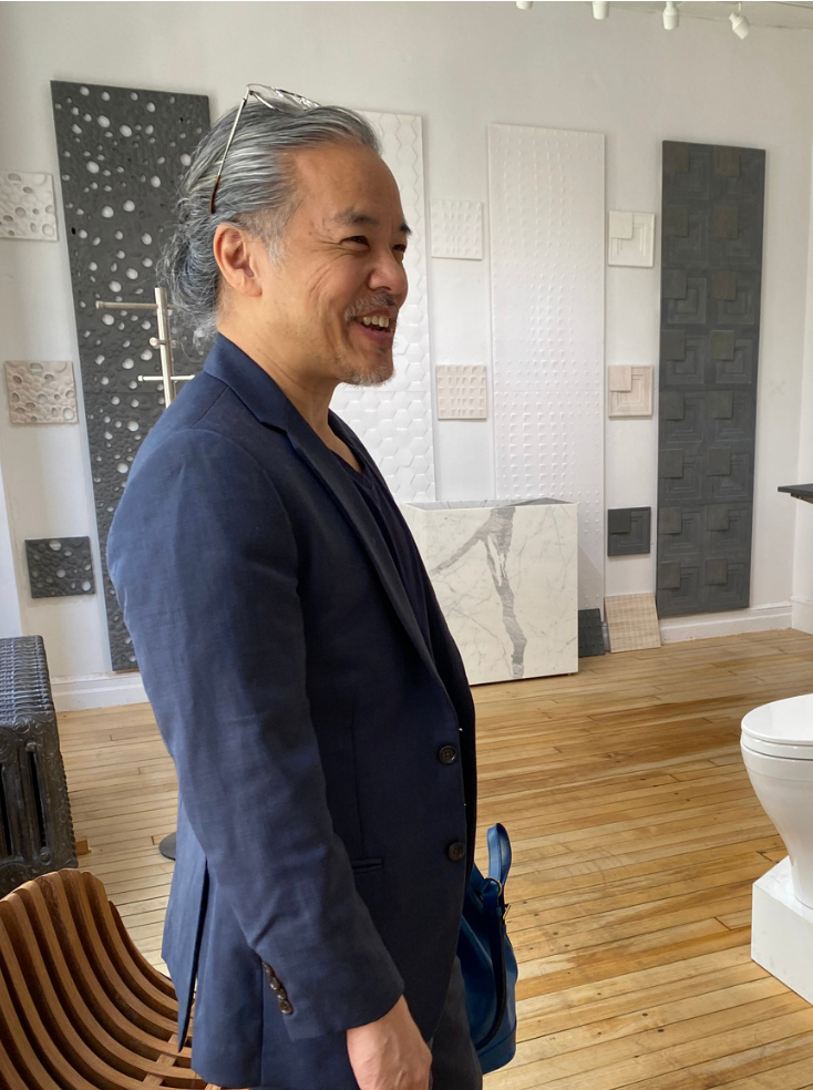 NYC interior designer Jarret Yoshida standing inside a bathroom showroom