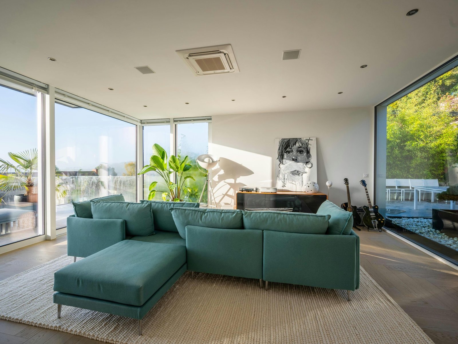 Blog Living room with natural light and green palm plants and a green couch. natural elements