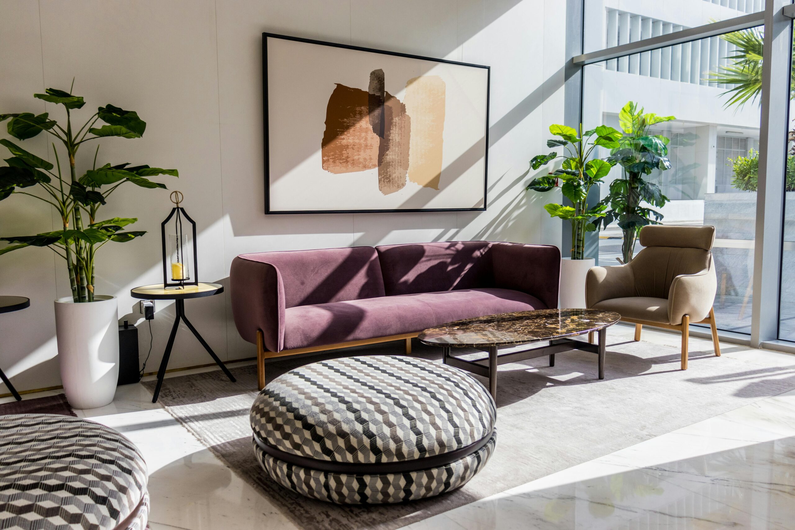 Sunlit living room with modern furnishings, purple couch and plants